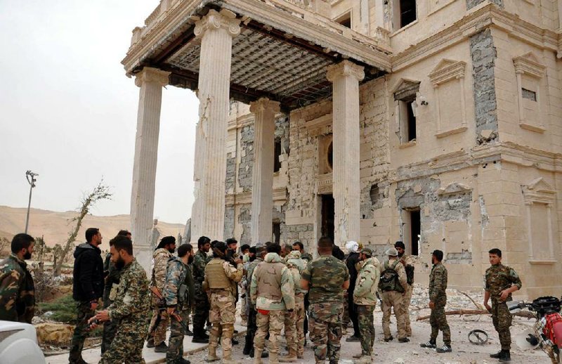 Syrian government soldiers gather outside a damaged palace in Palmyra, central Syria, in this file photo released on March 24. Islamic State fighters retook Palmyra from Syrian troops on Sunday.