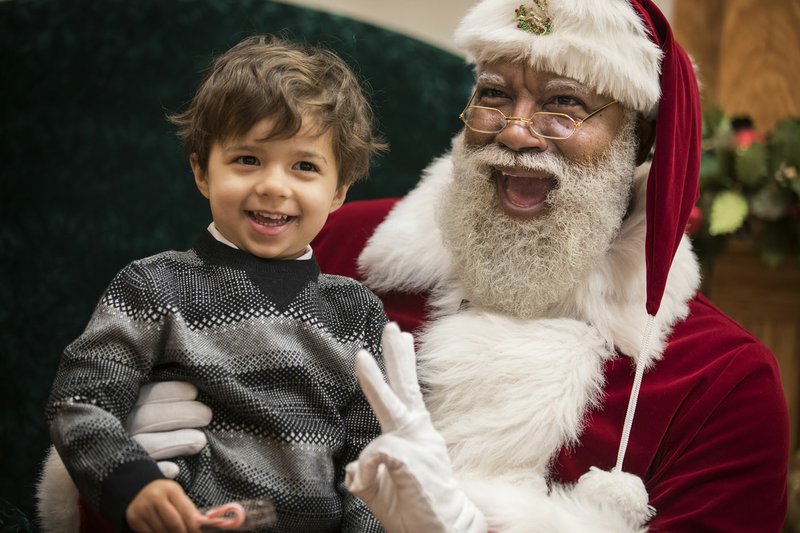 Larry Jefferson, playing the role of Santa, smiles with Jack Kivel, of Prior Lake, for photos Dec. 1 at the Santa Experience at Mall of America in Bloomington, Minn.