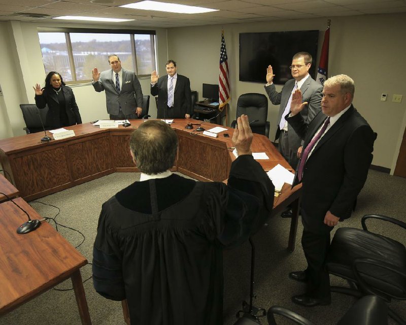 Arkansas Supreme Court Associate Justice Robin Wynne on Mondayswears in members of the Arkansas Medical Marijuana Commission (clockwise from upper left): Dr. Ronda Henry-Tillman, Travis Story, Dr. Carlos Roman, Stephen Carroll and James Miller. Henry-Tillman was elected chairman at the panel’s first meeting.