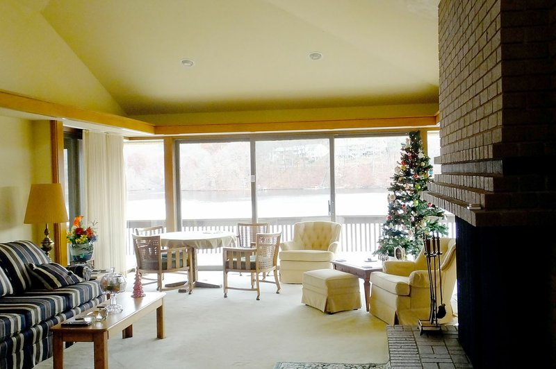Lynn Atkins/The Weekly Vista The living room and the deck just beyond the window offer a view of Lake Windsor. There are three fireplaces in the home and a fully enclosed sun room.