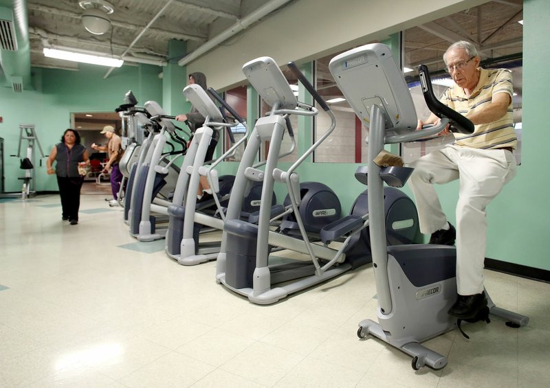 Tom Davis, of Springdale, uses a cycling exercise machine Tuesday at The Jones Center in Springdale. The center received $290,000 from the Walmart Foundation for three focus points at the center that includes recreation, meeting spaces and youth programs. The work out area will receive extensive expansion and renovation.