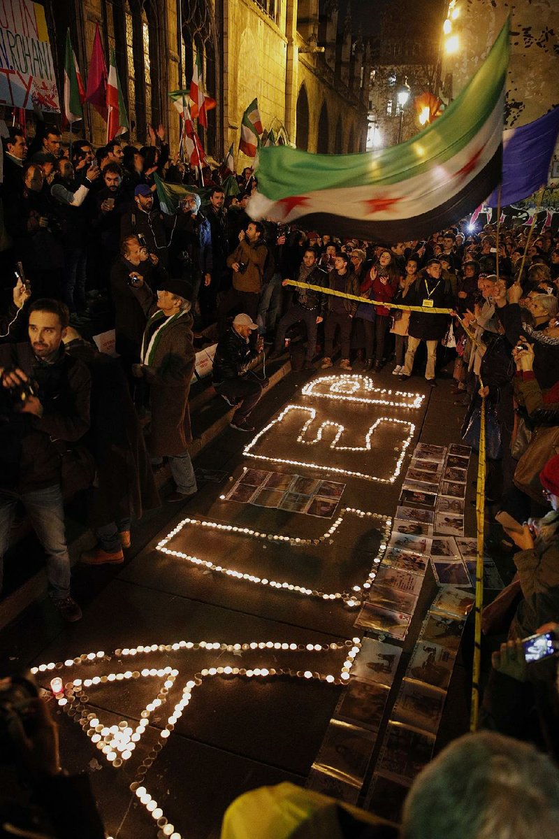 People gather at candles spelling Aleppo on Wednesday in Paris to show support for residents of the besieged Syrian city, where shelling was resumed, delaying a planned evacuation.