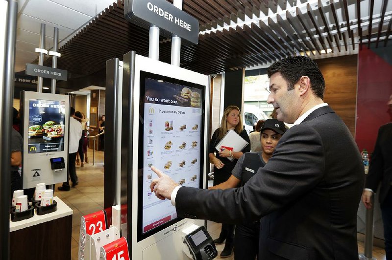 McDonald’s CEO Steve Easterbrook demonstrates an order kiosk, with cashier Esmirna DeLeon, during a presentation at a McDonald’s restaurant in New York’s Tribeca neighborhood, last month.