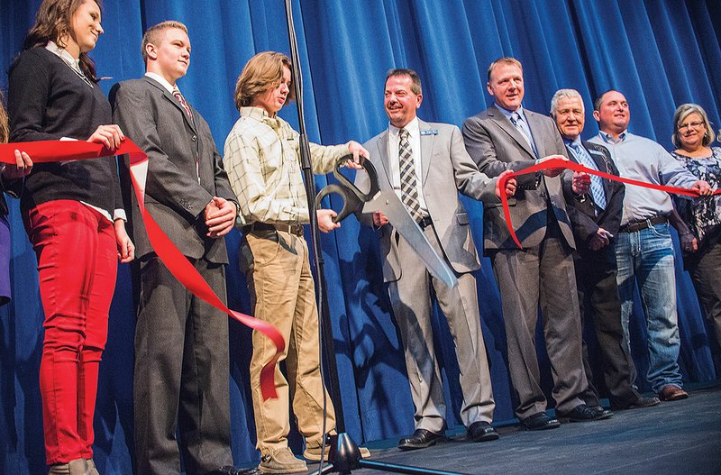 Kolton Peacock, a senior, cuts the ribbon during the celebration of Southside Charter High School’s new auditorium. Peacock is joined by Superintendent Roger Rich, fourth from left, along with members of the school board and the Batesville Area Chamber of Commerce.