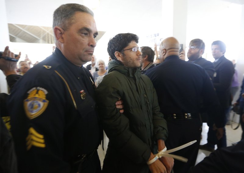 A protester is arrested Friday outside the House gallery during a special session of the North Carolina General Assembly at the Legislative Building in Raleigh.