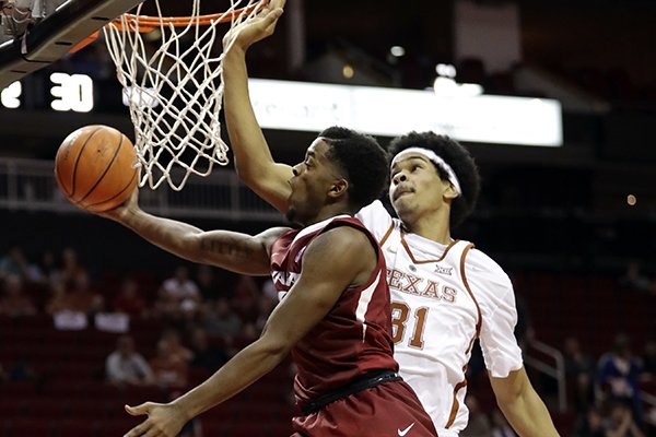 Arkansas' Daryl Macon (4) goes up to shoot as Texas' Jarrett Allen (31) defends during the second half of an NCAA college basketball game Saturday, Dec. 17, 2016, in Houston. (AP Photo/David J. Phillip)

