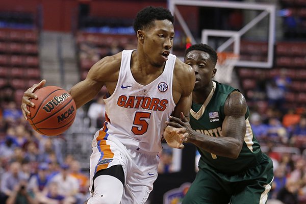 Florida guard KeVaughn Allen (5) drives past Charlotte guard Braxton Ogbueze (1) in the first half of an NCAA college basketball game in the Orange Bowl Classic tournament, Saturday, Dec. 17, 2016, in Sunrise, Fla. (AP Photo/Joe Skipper)

