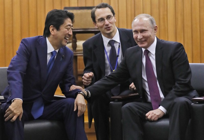 Russian President Vladimir Putin (right) chats with Japanese Prime Minister Shinzo Abe (left) on Friday during their visit to the Kodokan Judo Institute, the headquarters of the worldwide judo community, in Tokyo. 