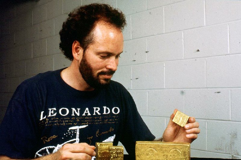 In this undated photo provided by Milt Butterworth, treasure hunter Tommy Thompson smiles at gold he found at the bottom of the Atlantic Ocean in the wreckage of the SS Central America, which sank in a hurricane off the coast of South Carolina in 1857.  