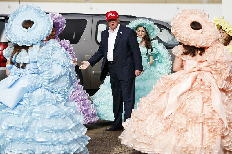 President-elect Donald Trump is greeted Saturday at the airport in Mobile, Ala., by Azalea Trail Maids dressed in antebellum Southern-style outfits as he arrives for a rally in the city.