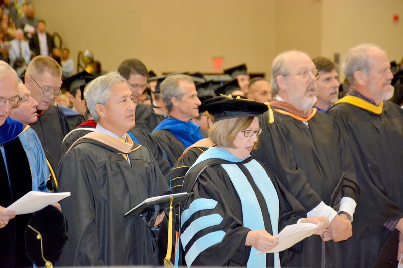 Graham Thomas/Herald-Leader Members of the John Brown University faculty and sing the JBU Alma Mater at the conclusion of Fall 2016 Commencement on Saturday at Bill George Arena.