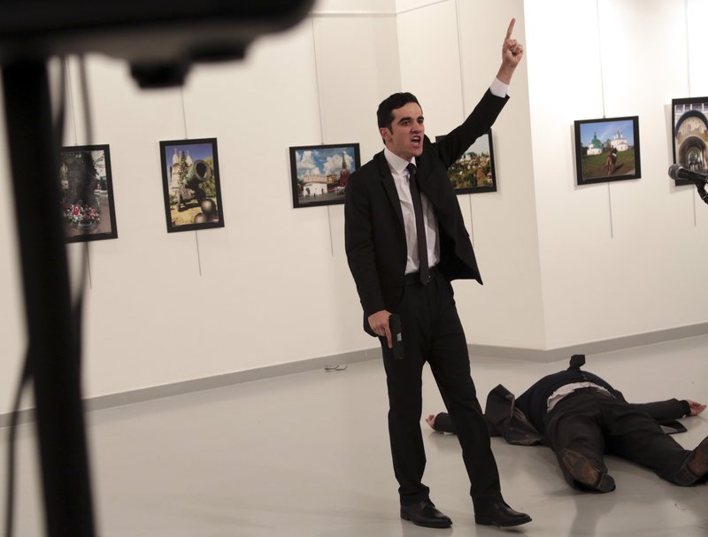 An unnamed gunman shouts after shooting the Russian Ambassador to Turkey, Andrei Karlov, at a photo gallery in Ankara, Turkey, Monday, Dec. 19, 2016. A Russian official says that the country's ambassador to Turkey has died after being shot by a gunman in Ankara. (AP Photo/Burhan Ozbilici)