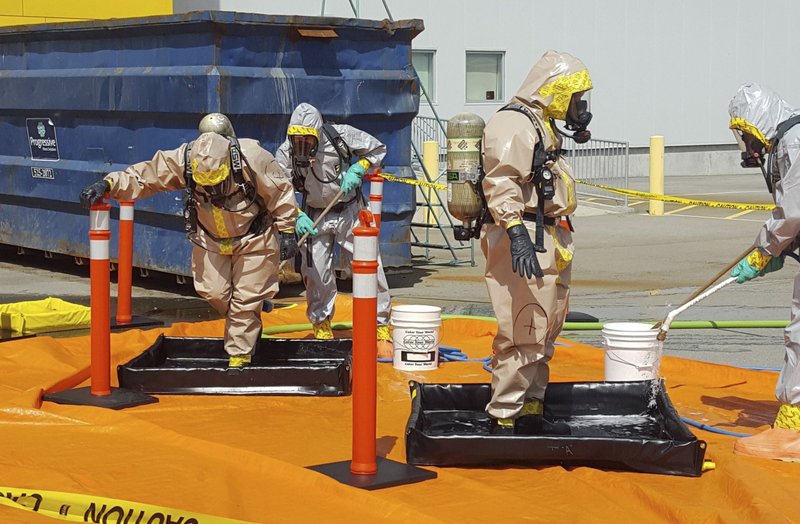 In this June 27, 2016 file photo provided by the Royal Canadian Mounted Police, members of the RCMP go through a decontamination procedure in Vancouver after intercepting a package containing approximately 1 kilogram (2.2 pounds) of the powerful opioid carfentanil imported from China. U.S. assertions that China is the top source of the synthetic opioids that have killed thousands of drug users in the U.S. and Canada are unsubstantiated, Chinese officials told the Associated Press. 
