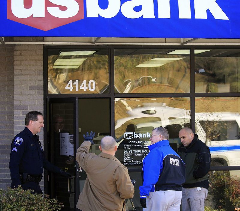 North Little Rock police and detectives investigate a bank robbery Tuesday at US Bank, 4140 John F. Kennedy Blvd.