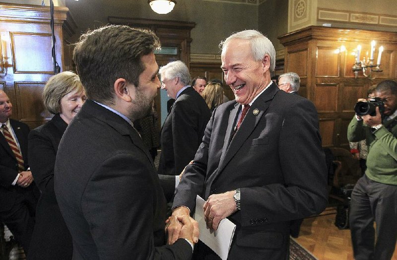 Gov. Asa Hutchinson (right) jokes with Arkansas Senate President Pro Tempore Jonathan Dismang while greeting legislators after a news conference Tuesday outlining his priorities for the legislative session starting Jan. 9. The governor sorted his policy plans into three categories: economic development, education, and efficiency and government transformation.