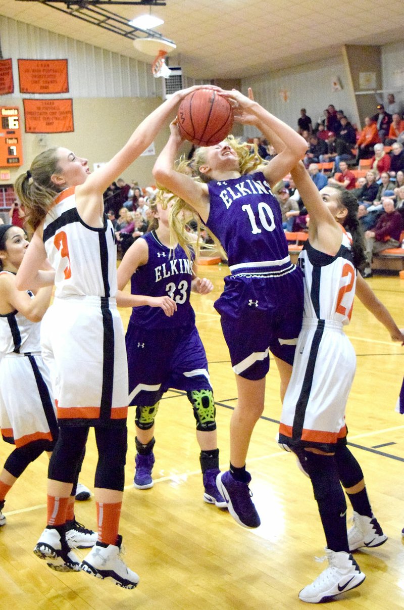 Photo by Mike Eckels Lady Lions&#8217; Kyrstin Branscum (left) and Tori Foster (right) block a jump shot attempt by a Lady Elks player during the Dec. 16 Gravette-Elkins basketball contest at Lion Field House in Gravette. The Lady Lions took the victory during the 2016 homecoming basketball game, 53-46.