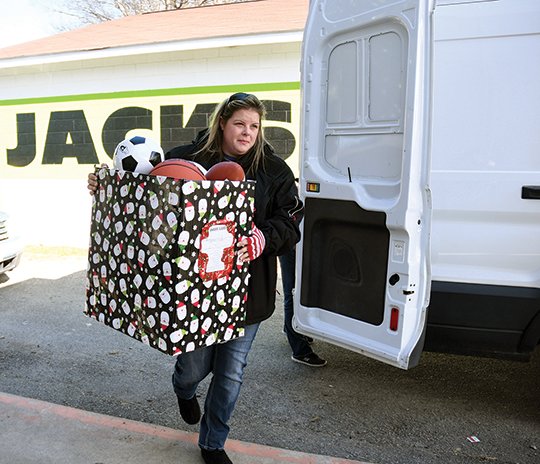 The Sentinel-Record/Mara Kuhn A TON OF TOYS: Janet Willis, founder of Miracles From Matthew, carries in some of the almost 1,000 toys her organization donated to Jackson House Tuesday. Willis started the organization in 2013 after the death of her 8-month-old son, Matthew Scott Bailey, who was born with heart defects and other medical problems.