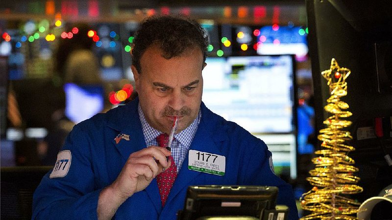 Gerard Farco follows stock prices Wednesday while working at the New York Stock Exchange.