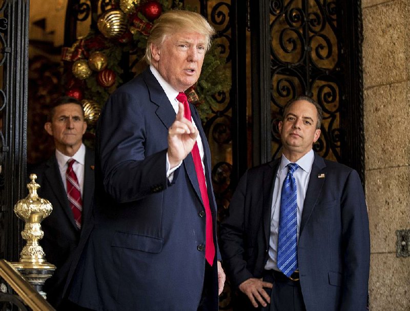 President-elect Donald Trump, center, accompanied by Trump Chief of Staff Reince Priebus, right, and retired Gen. Michael Flynn, a senior adviser to Trump, left, speaks to members of the media at Mar-a-Lago, in Palm Beach, Fla., Wednesday, Dec. 21, 2016. (AP Photo/Andrew Harnik)