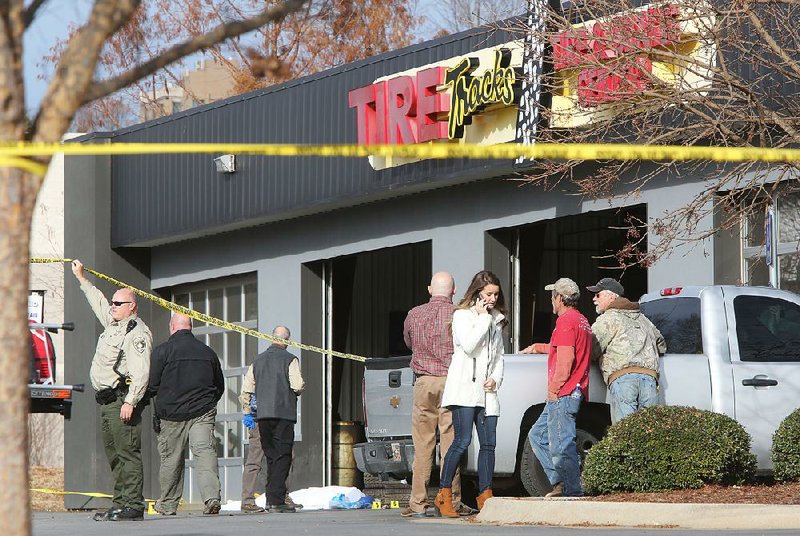Law enforcement personnel investigate an officer-involved shooting Wednesday at Tire Tracks on South School Avenue in Fayetteville. The Washington County sheriff’s office said that Cpl. Brad Robinson shot and killed an unidentified man who was brandishing a knife.