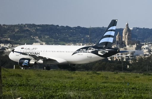 In this frame grab taken from television a hijacked Afriqiyah Airways A320 sits on the tarmac at Malta International airport Friday Dec. 23, 2016. Malta's state television says two hijackers who diverted a Libyan commercial plane to the Mediterranean island nation have threatened to blow it up. (Photo TVM via AP)
