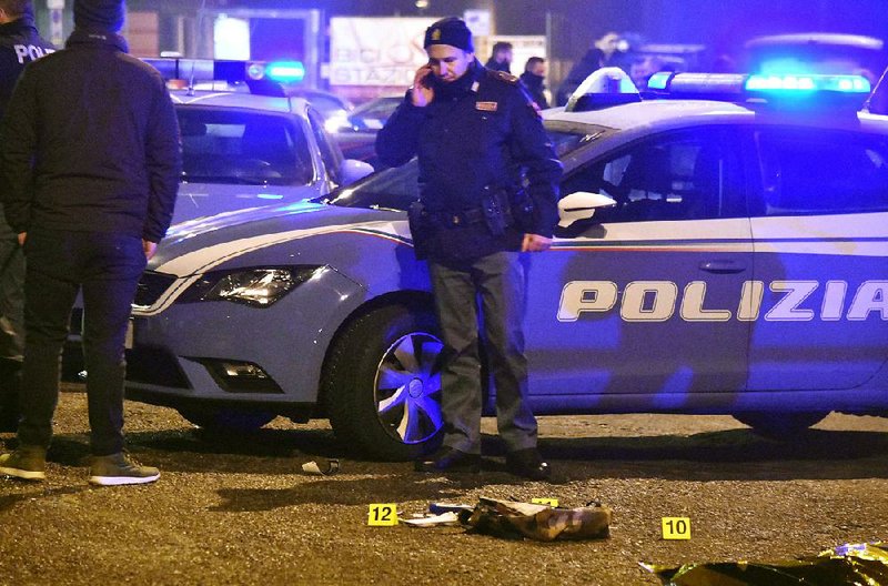 An Italian police officer in Milan works at the scene of a shootout early Friday where the suspect in the deadly truck attack on a Berlin market was killed.