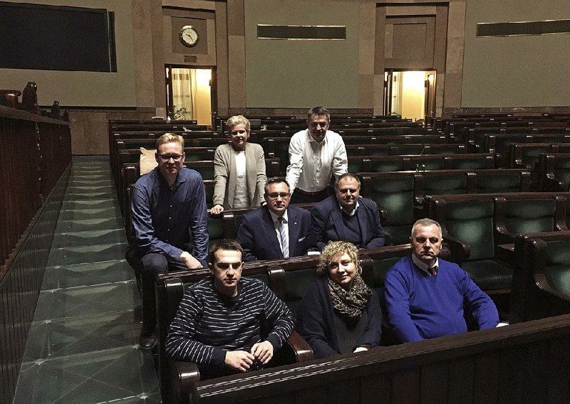 Michal Stasinski (second row left) and other lawmakers protesting the Polish government pose inside the parliament plenary hall in Warsaw in this photo released by Stasinski.