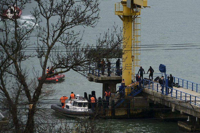 Russian rescue workers collect wreckage from a crashed plane at a pier just outside Sochi, Russia, on Sunday. The plane was carrying 92 people.