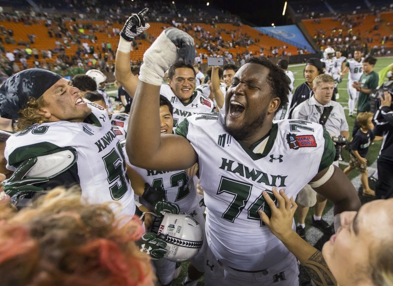 Hawaii offensive lineman RJ Hollis (74) and his teammates celebrate after defeating Middle Tennessee 52-35 in the Hawaii Bowl NCAA college football game, Saturday, Dec. 24, 2016, in Honolulu. 