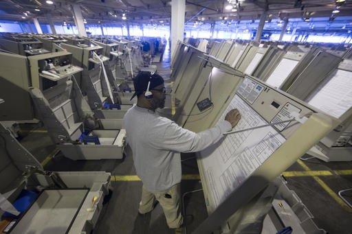 In this Oct. 14, 2016 photo, a technician works to prepare voting machines to be used in the upcoming election in Philadelphia. These paperless digital voting machines, used by roughly one in five U.S. voters last month, present one of the most glaring dangers to the security of the rickety, underfunded U.S. election system. Like many electronic voting machines, they are vulnerable to hacking. But other machines typically leave a paper trail that could be manually checked. 