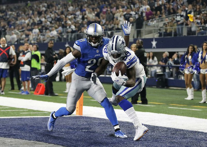 Dallas wide receiver Dez Bryant (right) gains control of the ball while Detroit defensive back Johnson Bademosi looks on during Monday night’s game. Bryant finished with two touchdown catches and threw a 10-yard scoring pass to Jason Witten to carry the Cowboys past the Lions 42-21.