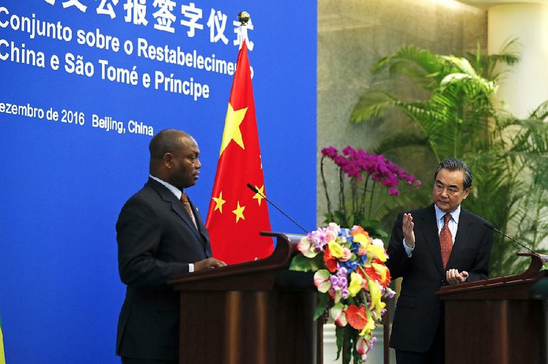 Chinese Foreign Minister Wang Yi (right) speaks next to his Sao Tome counterpart Urbino Botelho during a joint news statement at the Diaoyutai State Guesthouse in Beijing on Monday. China and Sao Tome and Principe officially resumed diplomatic relations on Monday.