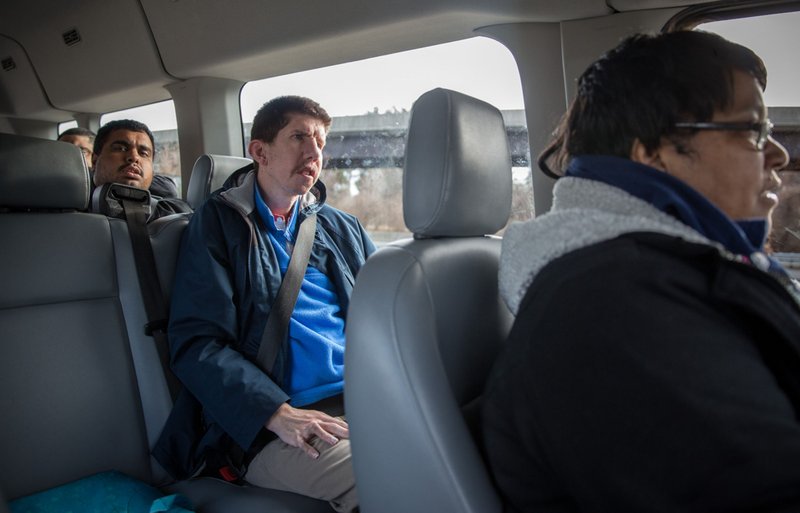 Matt Kidder, who has cerebral palsy, and other individuals in the day support program at Chimes Virginia ride to a community food bank in a van driven by Faith Rojas, a life-skills coach for adults with intellectual and developmental disabilities. 