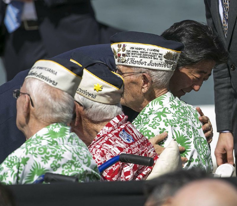 Japanese Prime Minister Shinzo Abe hugs Pearl Harbor survivor Everett Hyland after speaking Tuesday at Joint Base Pearl Harbor-Hickam near the USS Arizona Memorial.