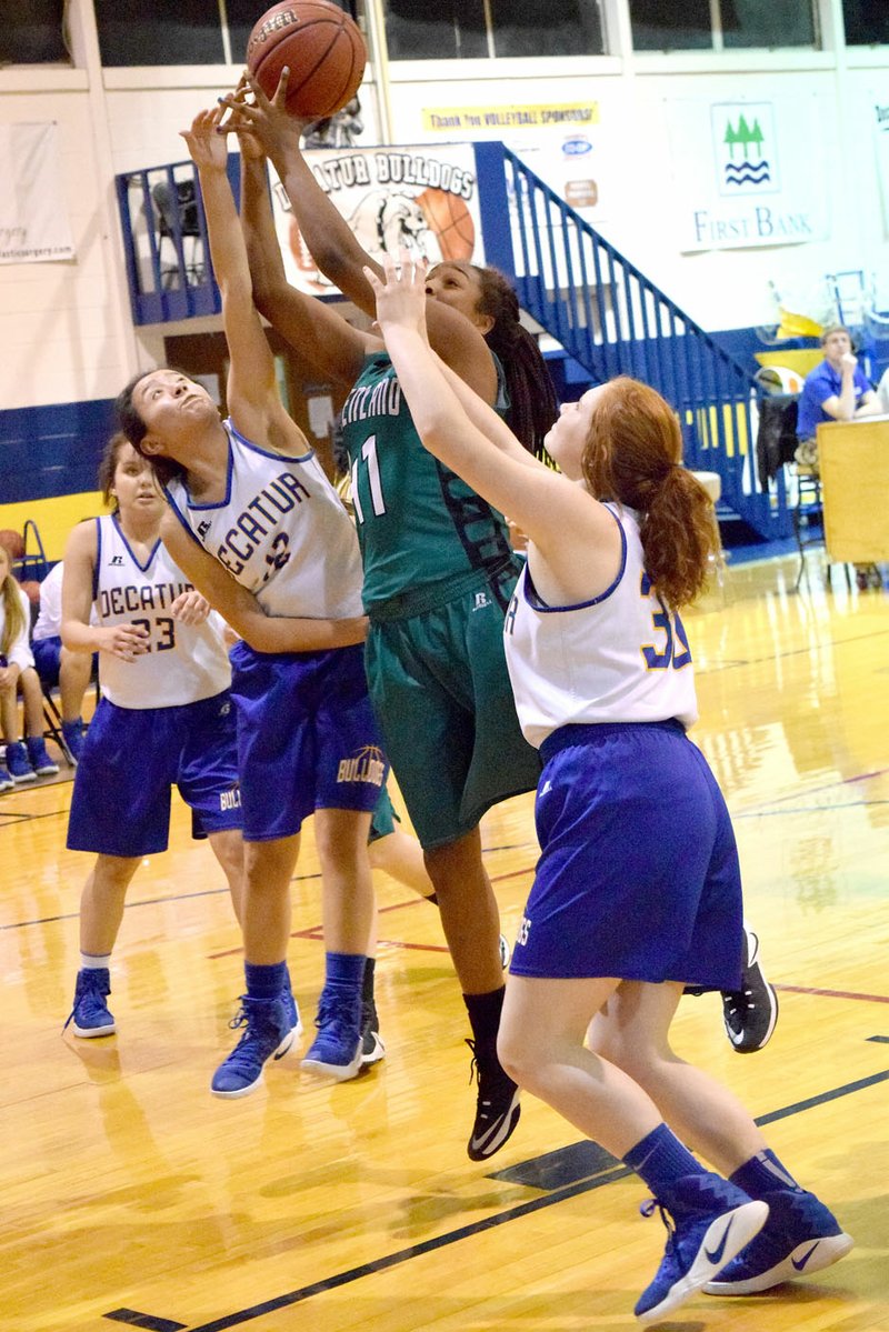 Photo by Mike Eckels With Abby Tilley (23, left) ready to intercept a rebound, Deysi Rubi (center, left) and Bronwyn Berry (30, right) tried to block a Pirate shooter during the Dec. 19 Decatur-Prairie Grove junior high contest at Peterson Gym in Decatur.