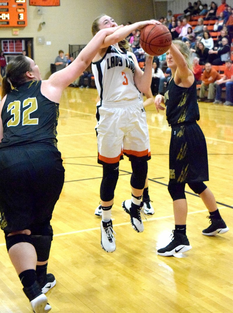 Photo by Mike Eckels Gravette&#8217;s Kyrstin Branscum fights for the basketball against two West Fork defenders during the Dec. 20 Lady Lions-Lady Tigers game at Lion Field House in Gravette.