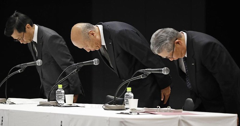 Tadashi Ishii, president of Japanese advertising company Dentsu (center), apologizes with other executives Wednesday in Tokyo over the suicide of an employee. 