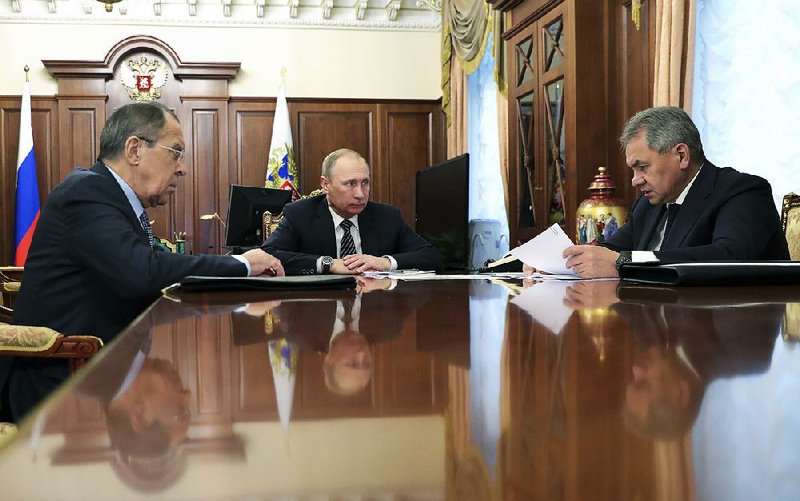 Russian President Vladimir Putin (center) confers Thursday at the Kremlin with Foreign Minister Sergey Lavrov (left) and Defense Minister Sergei Shoigu on the situation in Syria.