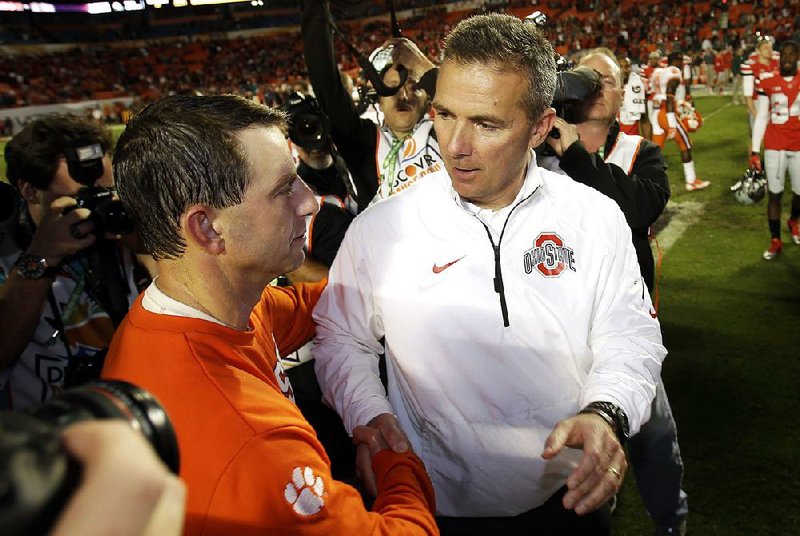 Clemson Coach Dabo Swinney (left) shakes hands with Ohio State Coach Urban Meyer after the 2014 Orange Bowl, which the Tigers won 40-35. Since 2011, Swinney is 68-14, including that bowl victory, which is one of two postseason losses on Meyer’s record (10-2).