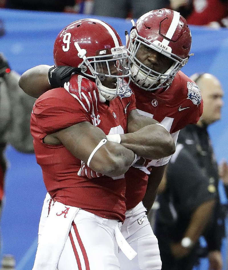 Alabama offensive lineman Cam Robinson (right) celebrates with Alabama running back Bo Scarbrough after Scarbrough scored on an 18-yard run during the first quarter of the Peach Bowl on Saturday in Atlanta. Scarbrough rushed for 180 yards and 2 touchdowns on 19 carries in the Crimson Tide’s 24-7 victory.