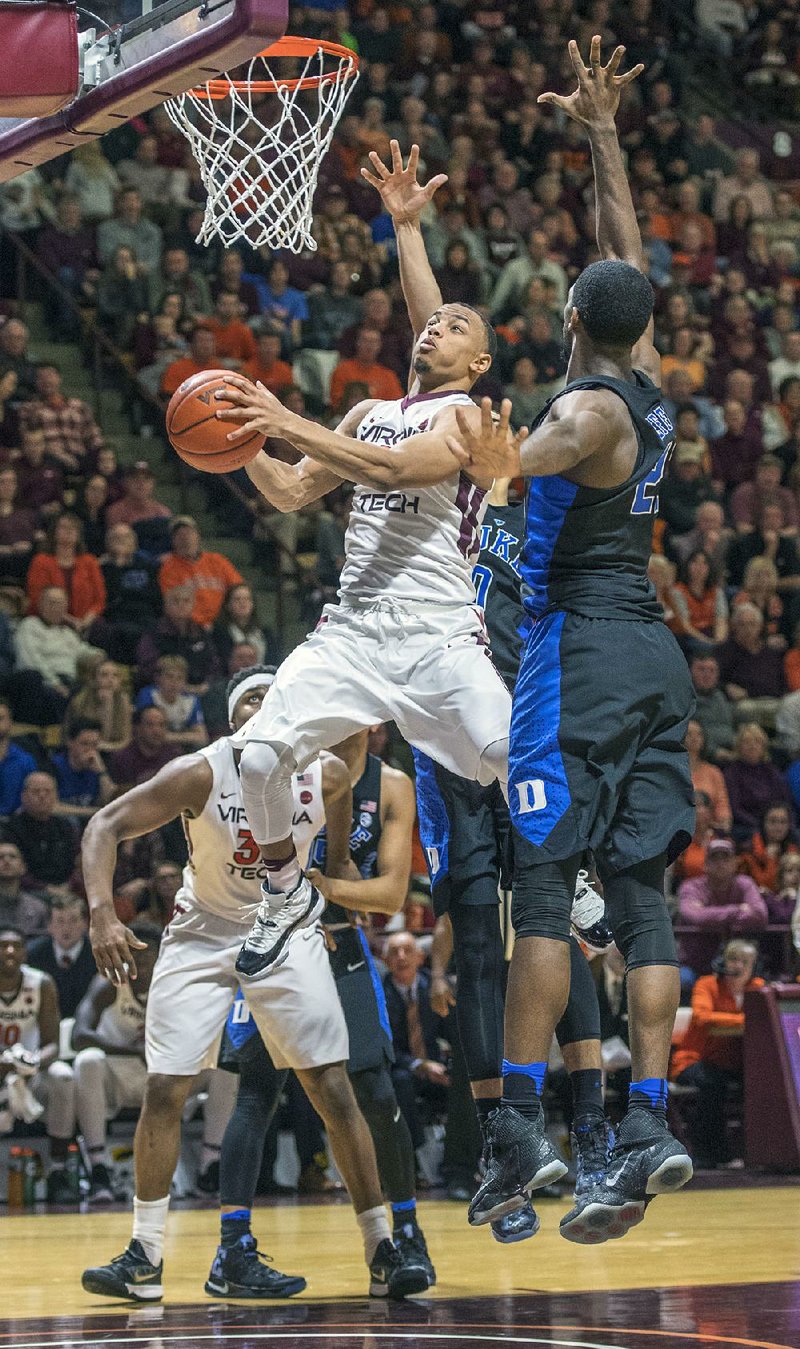 Virginia Tech guard Justin Robinson (5) goes up for a basket against Duke forward Amile Jefferson (right) in the second half of the Hokies’ 89-75 victory in Blacksburg, Va., on Saturday. 