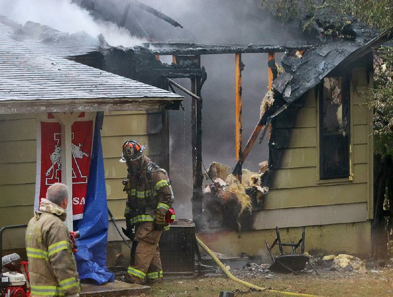 12/31/16
Arkansas Democrat-Gazette/STEPHEN B. THORNTON
A Little Rock firefighter walks away from the rear of a home which caught fire along Joyce Court Saturday afternoon in Little Rock. Noone was home at the time but a dog perished in the fire, according to firefighters at the scene.
