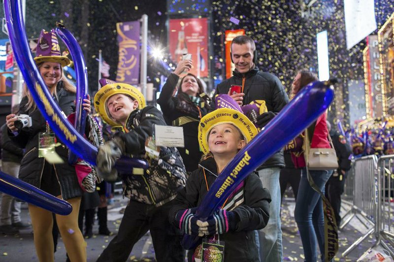 Children join the crowd Saturday night at Times Square in New York. Officials estimated that 1 million people gathered to help ring in the New Year. 