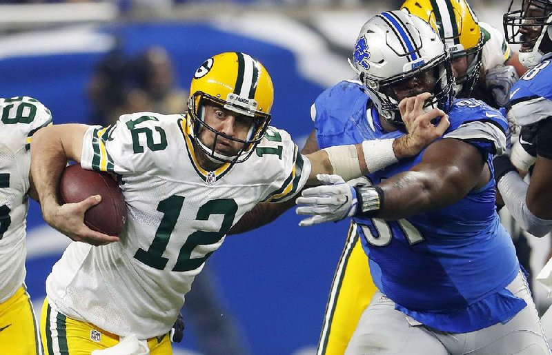 Green Bay Packers quarterback Aaron Rodgers (12) stiff arms Detroit Lions defensive tackle A’Shawn Robinson (91) during the second half of Sunday’s game in Detroit. Rodgers threw three of his four touchdown passes in the second half as Green Bay beat Detroit 31-24 to win the NFC North.
