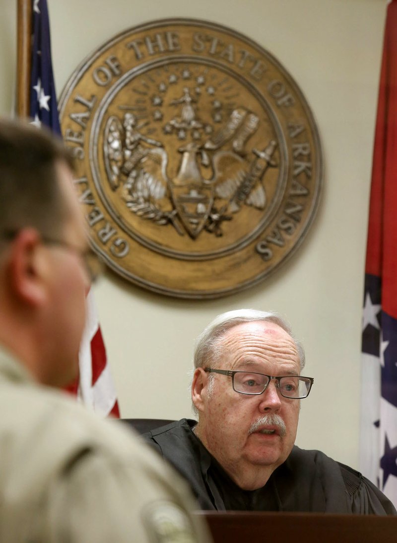 Ray Reynolds, Elkins district judge and Washington County Circuit Court magistrate, holds arraignment procedures Wednesday inside the courtroom at the Washington County Detention Center in Fayetteville. Reynolds is stepping down after 32 years as a district judge and about 10 years as the Washington County Circuit Court magistrate.