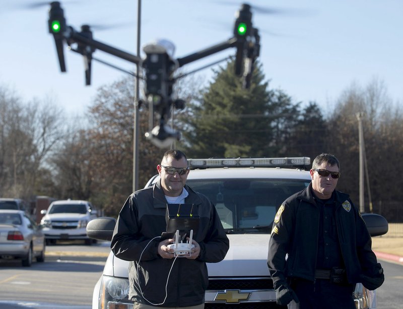 Rogers Police Sgt. Miles Mason (right) watches as Cpt. Jarod Mason flies the department's DJI Inspire 1 v2.0 quadcopter on Monday, Dec. 19, 2016, behind the Rogers Police Department.