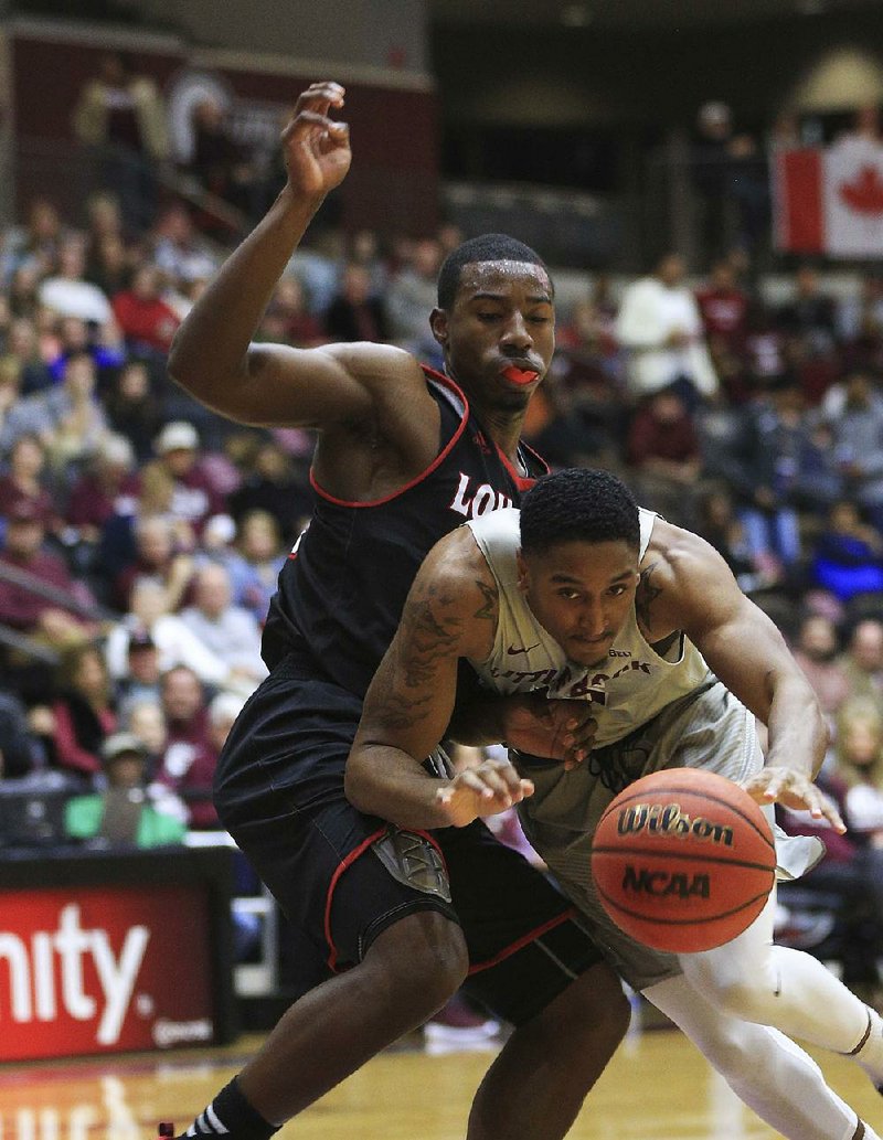 UALR forward Stetson Billings (right) tries to drive past Louisiana-Lafayette’s Johnathan Stove during their game Monday at the Jack Stephens Center in Little Rock. The Trojans lost 69-52.