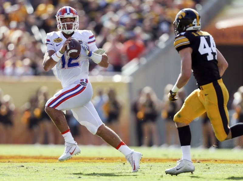 Florida quarterback Austin Appleby scrambles away from Iowa linebacker Ben Niemann during Monday’s Outback Bowl in Tampa, Fla. Appleby threw for 222 yards and two touchdowns in the Gators’ victory.