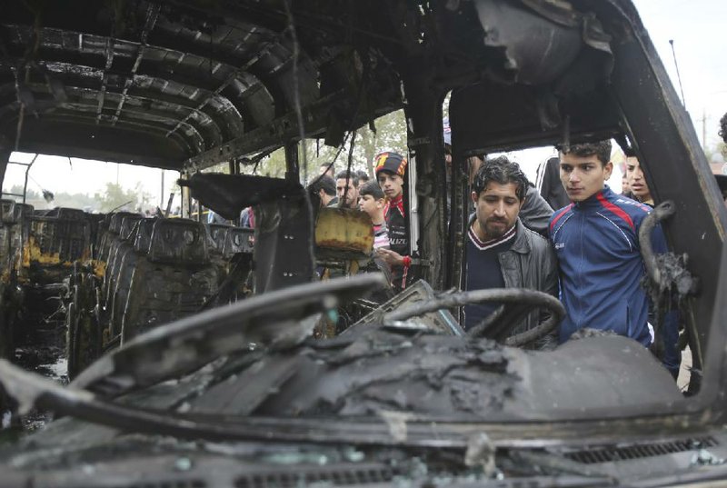 Residents inspect the scene after a truck bomb explosion at a crowded outdoor market in the Iraqi capital’s eastern district of Sadr City on Monday.