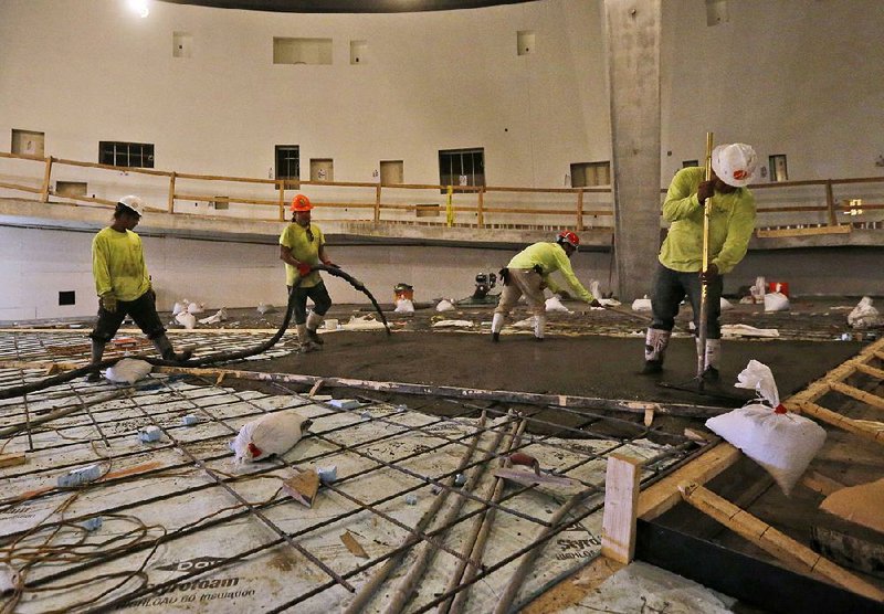 Workers pour concrete last month at the Patricia and Phillip Frost Museum of Science under construction in Miami. U.S. constructionproject spending rose 0.9 percent in November, the Commerce Department said Tuesday. 